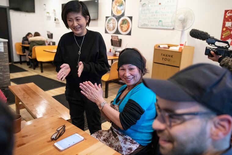 Lily Yau (center) claps along with Hong-Kai Wang (left) and Eric Laska after singing a Cantonese song at her restaurant, Hidden Gem, in Chinatown.