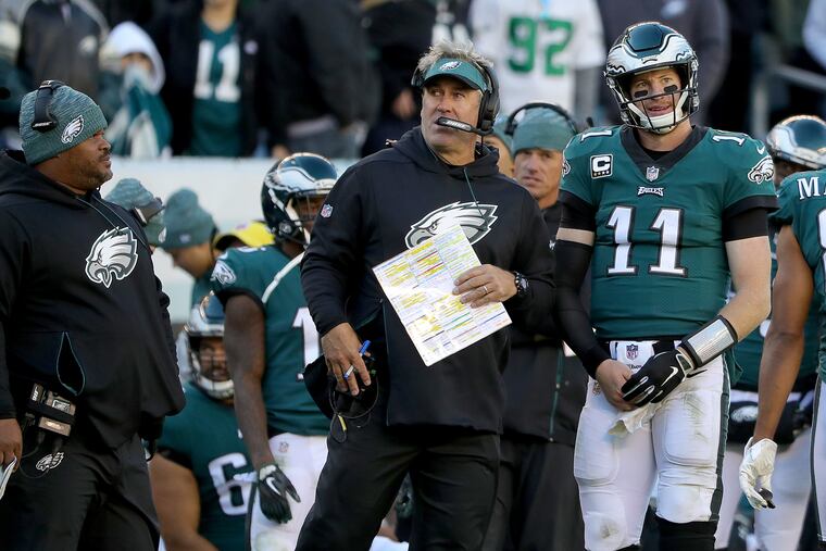 Eagles head coach Doug Pederson, center, and Carson Wentz talk as they wait for an instant replay in the 4th quarter. Philadelphia Eagles lose 21-17 to the Carolina Panthers in Philadelphia, PA on October 21, 2018. DAVID MAIALETTI / Staff Photographer