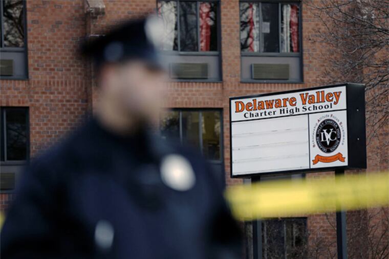 A police officer stands by caution tape at the Delaware Valley Charter School Friday, Jan. 17, 2014. (AP Photo/Matt Rourke)
