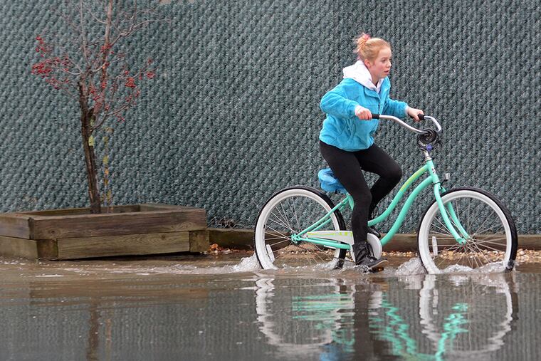 Corinne Wiederhold, 14, makes her way to a friend's house in Ocean City as rain, winds and high tides pound the N.J. Shore on Dec. 9, 2014. ( TOM GRALISH / Staff Photographer )