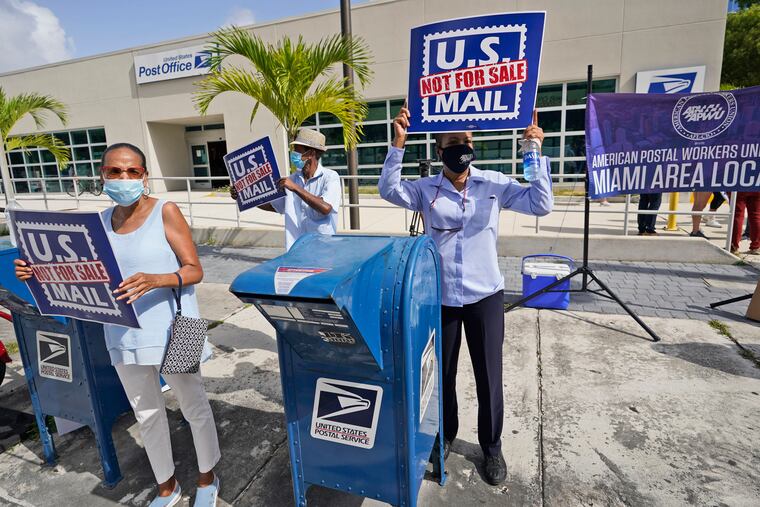Protesters demonstrate during a "National Day of Action to Save the "Peoples" Post Office!" outside the Flagler Station post office, Tuesday in Miami.
