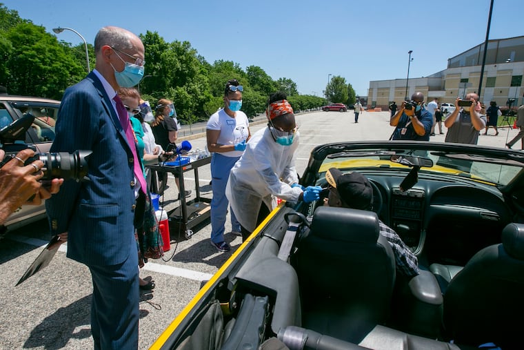 Dr. Ala Stanford, center, tests Joel Watson of Philadelphia for COVID-19 while city Health Commissioner Thomas Farley, left, watches, on June 9.
