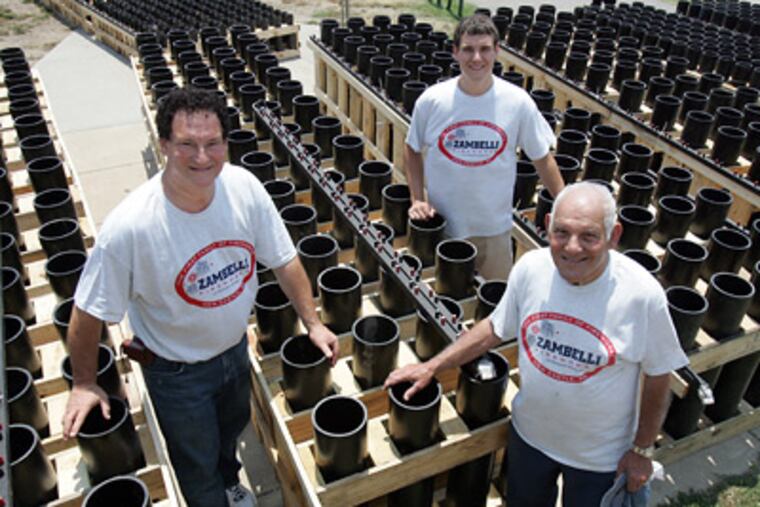 George Zambelli, 60, (left) with his uncle Louis, 82, and son Jared, 20, stand inside rows of mortars behind the Art Museum, set for tonight's fireworks show. (Barbara L. Johnston/Staff Photographer)