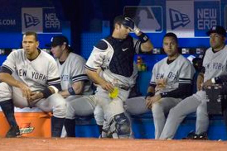 The faces and body language say it all as (from left) Alex Rodriguez, Jason Giambi, Jorge Posada, Derek Jeter and Miguel Cairo watch the Yankees close out another loss on Monday. New York has split the first two games of a series against first-place Boston this weekend.