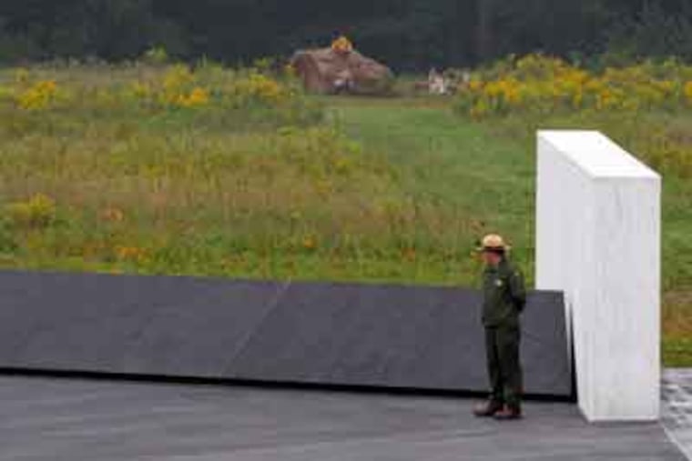A National Park ranger stands near a section of phase I of the permanent Flight 93 National Memorial near the crash site of United Flight 93 in Shanksville, Pa. Saturday Sept. 10, 2011. A 17-ton boulder marking the crash site is seen in background. (AP Photo/Amy Sancetta)