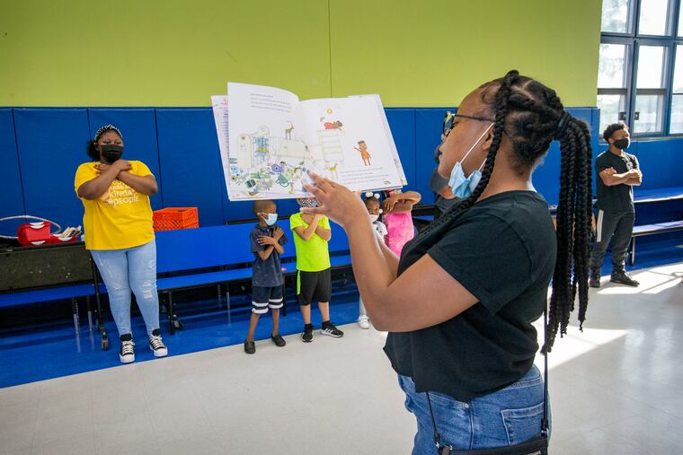 Bria Williams, lead coach at Freedom Schools Literacy Academy Harrity, reads Ada Twist Scientist by Andrea Beaty to students during Harambee circle.