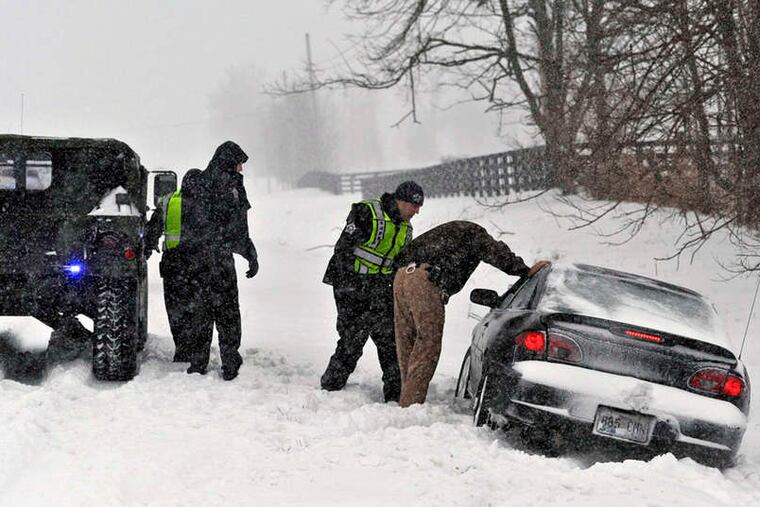 Boyle County sheriff's deputies traveling in a Hummer help a stranded motorist during a heavy snowstorm on U.S. 127 near Danville, Ky. The motorist had been headed to Danville Monday for medical treatment.