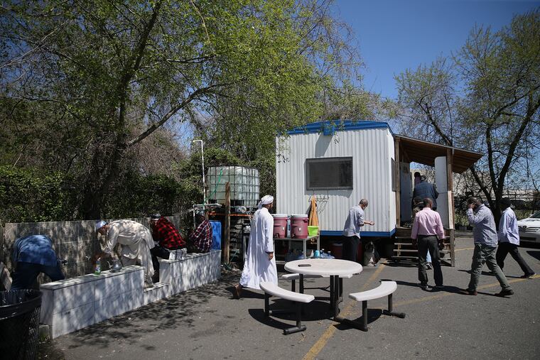 Muslim taxi drivers perform wudu, the ritual washing for purification before prayer, as the dhuhr (midday) prayer time begins at the makeshift mosque in the waiting lot for airport taxi drivers on Island Avenue in Philadelphia.