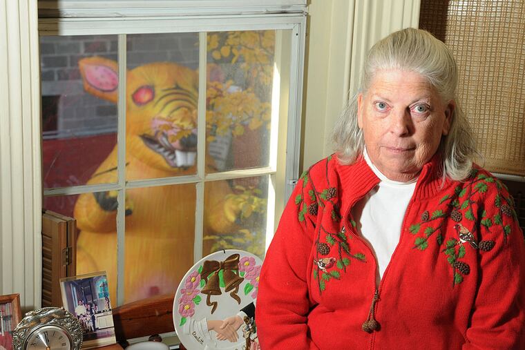 Charlotte Veazie, 69, in her second-floor bedroom overlooking a giant inflatable rat set up daily at a construction site across the street in a dispute over the use of non-union workers. The protesters play a recording of a baby crying -- loudly -- to accompany the rat.