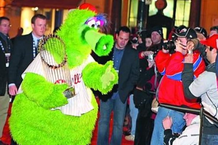 THE PHILLIE PHANATIC struts down the red carpet with the World Series trophy at the Bridge Cinema De Lux on Penn's campus last night, where the team held an advance screening of its World Series film. The DVD will be released to stores nationwide today.