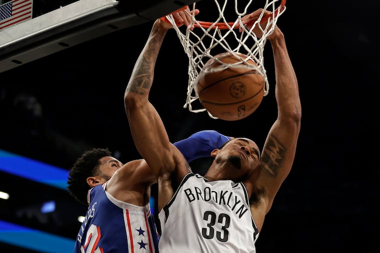 Brooklyn Nets center Nic Claxton (33) dunks in front of Philadelphia 76ers forward Tobias Harris during the first half of their game Tuesday in New York.