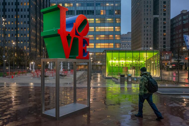 A lone pedestrian walking through LOVE Park on a rainy morning in late March.