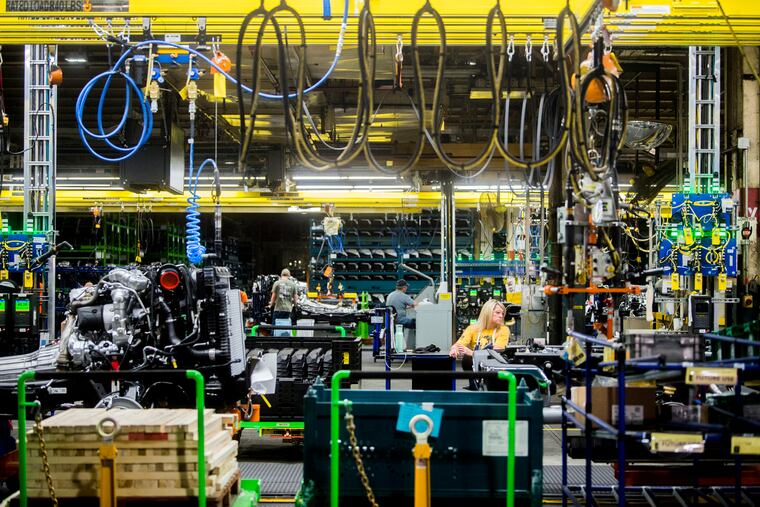 FILE - In this June 12, 2019, file photo General Motors employees work on the chassis line as they build the frame, power train and suspension onto the truck's body at the Flint Assembly Plant in Flint, Mich. On Tuesday, Sept. 3, the Institute for Supply Management, a trade group of purchasing managers, issues its index of manufacturing activity for August. (Jake May/The Flint Journal via AP, File)