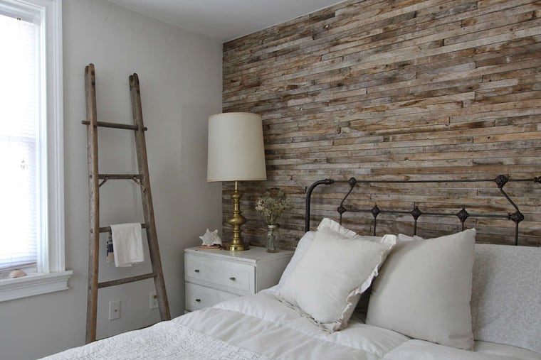 In this bedroom, the accent wall is covered with lath, unfinished wood strips.