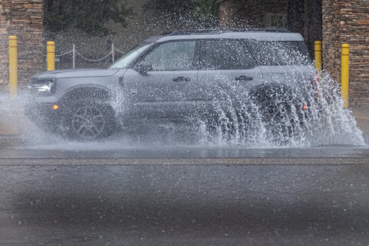 A vehicle plows through floodwaters on Columbus Boulevard Monday.