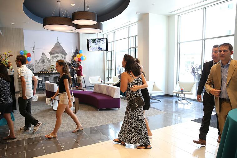 People walk through the lobby after a ribbon-cutting ceremony for 220 Rowan Blvd. in Glassboro. The new building includes student and market-rate apartments, and retail and medical space. (DAVID MAIALETTI / Staff Photographer)