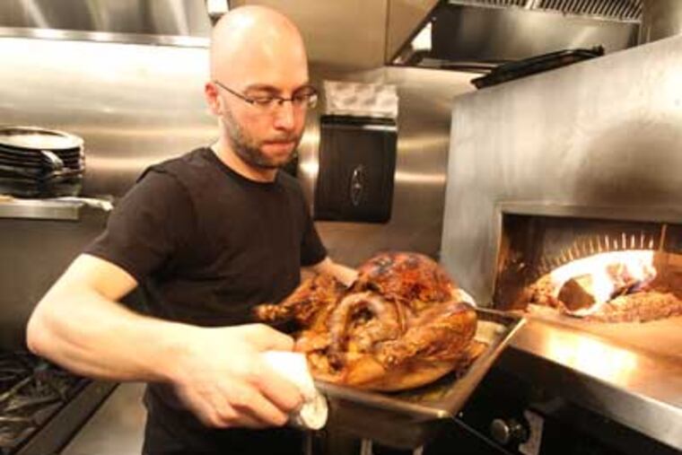 Greg Vernick, a local boy who is getting raves at his new restaurant, Vernick Food and Drink, shares his menu for a family Thanksgiving. He removes the apple cider and soy brine turkey from the restaurant's wood stove. ( Charles Fox / Staff Photographer )