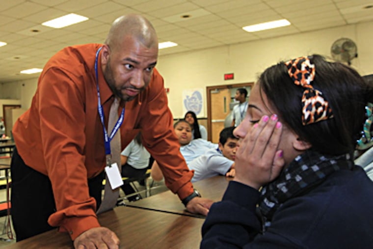 Hadrick, an alumnus and former athlete at Eisenhower, talks with student Jannelle Blake at lunchtime. (Michael Bryant / Staff Photographer)