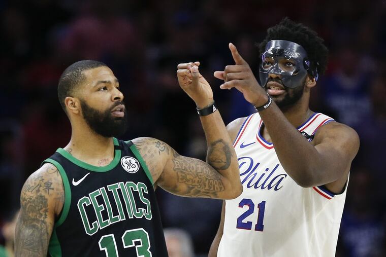 Sixers center Joel Embiid points his finger towards the score board while Boston Celtics forward Marcus Morris indicates a zero with his finger late in the fourth quarter during Game 4 of the Eastern Conference semifinals on Monday.