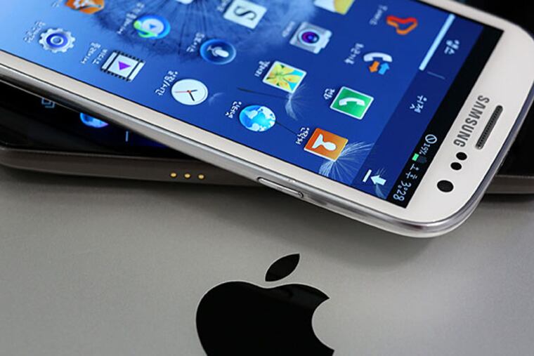 Samsung smartphones, Apple logo. A court ruled that Samsung still infringed on Apple's patent, but tossed some damages. Bloomberg