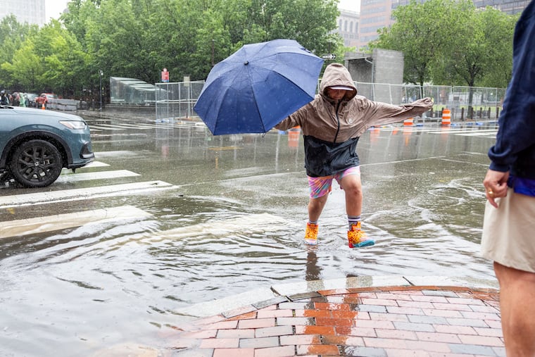 South Philadelphian John Nash, 12, jumps over a puddle during last week's rains that have help erase rain deficits.