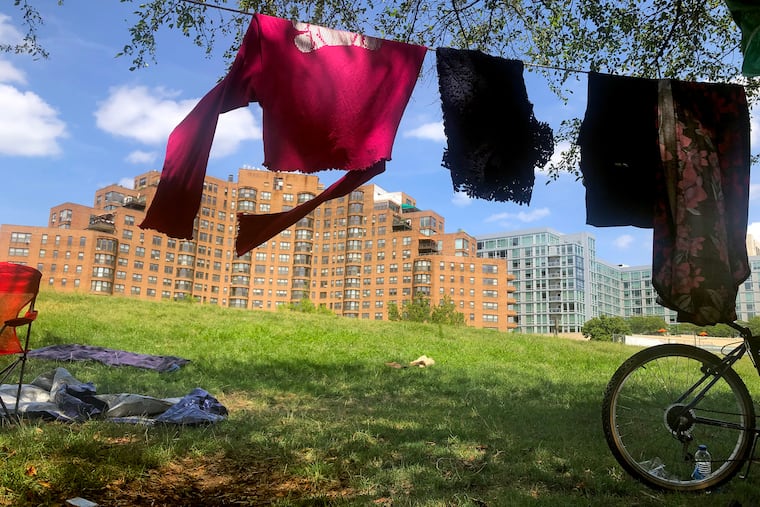 The laundry of Elizabeth Barksdale and Brandon Johnson hangs to dry outside their tent while they live in the homeless encampment on the Ben Franklin Parkway July 16, 2020.