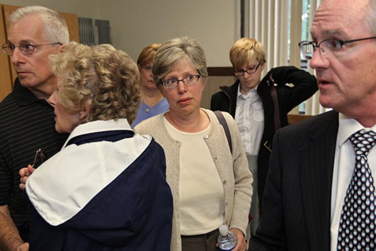 Surrounded by family members, Joe Mancini, husband, far left, Marge Yourshaw, mother, left, Barbara Mancini, center, listens to her attorney, Fred Fanelli, right, talk about what happened in court to the assembled media in the Schuykill County courthouse hallway on Thursday, October 10, 2013. ( MICHAEL BRYANT / Staff Photographer )