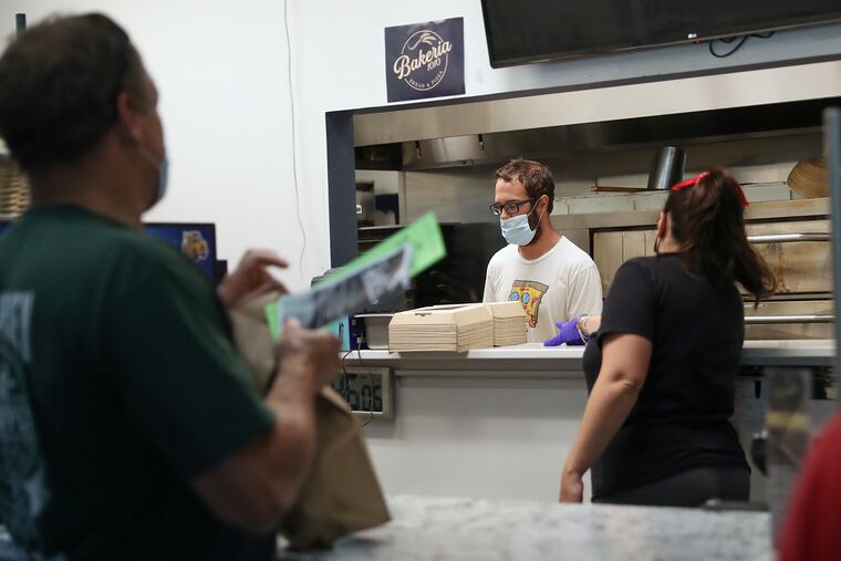 Mike Fitzick working behind the counter at Bakeria 1010 with his wife, Maura, during the height of COVID-19 in 2020.