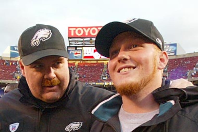 Andy Reid walks off the field with his son, Britt, after the Eagles beat the Giants in 2004. (Yong Kim / Staff file photo)