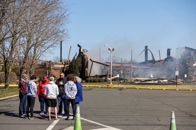 Church members and people in the community pray at the Fountain of Life Center fire. in Florence Township on Tuesday morning.