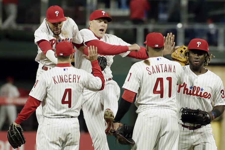 Phillies players celebrate their 6-1 win over the Reds.