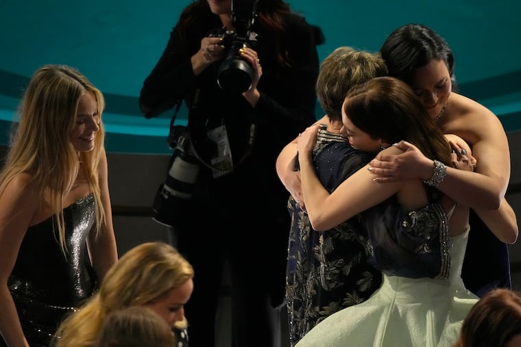 Margot Robbie, far left, looks on as Annette Bening, Lily Gladstone and Emma Stone embrace during the Oscars on Sunday, March 10, 2024, at the Dolby Theatre in Los Angeles.