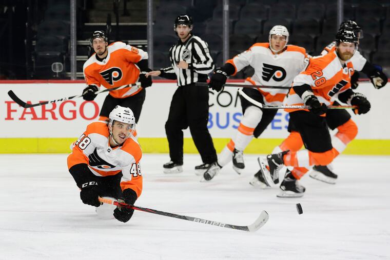 Center Morgan Frost falls forward passing the puck in the second period during a team scrimmage at the Wells Fargo Center on Sunday.