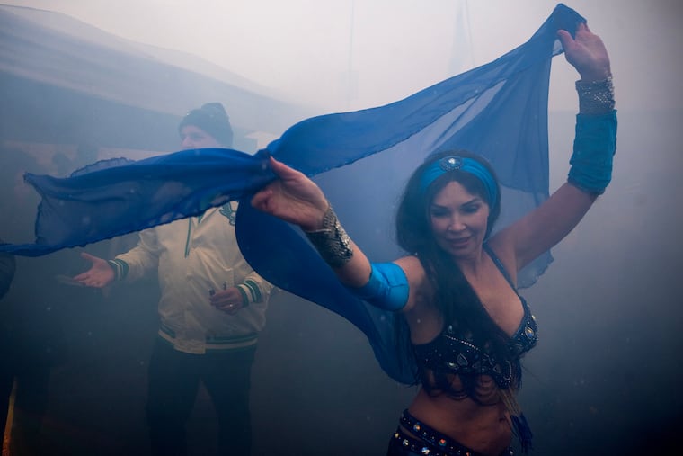 Professional belly dancer and instructor Kahina Asurah entertains tailgaters in smoky parking lots at Lincoln Financial Field on Sunday.