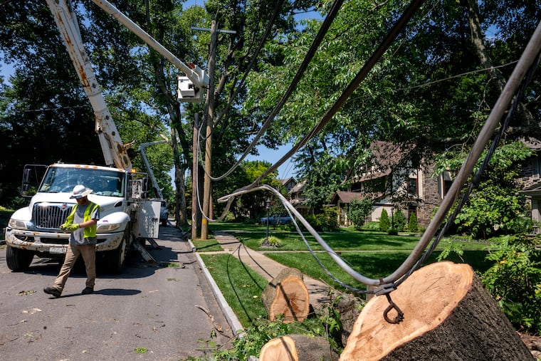 Utility workers restore power on Beacom Lane in Merion Station on Monday, as cleanup continues following the weekend’s microbursts.