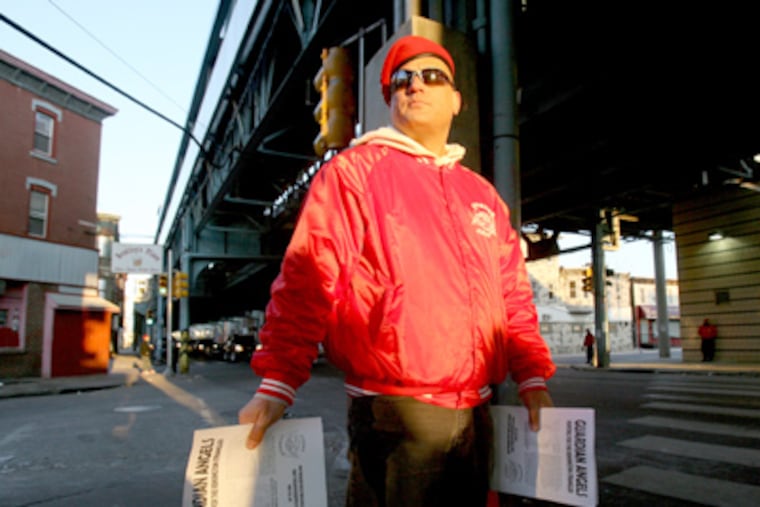 Guardian Angel Joe Crincoli hands out fliers of a sketch of the man believed to be the "Kensington Strangler" under the El at Kensington and Somerset avenues. (Charles Fox / Staff Photographer)