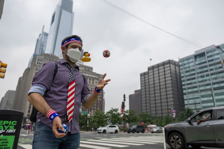 Julian Plotnick, Founder of 4 Day Philly, of Roxborough, Pa., is wearing a mask and juggling while waiting for his bus as wildfire smoke from Canada continues to pollute the air in Philadelphia, Pa., on Saturday, July 18, 2026.