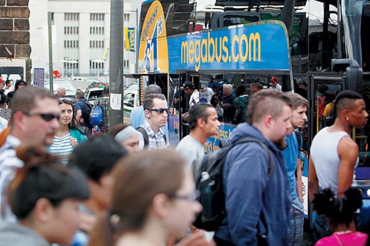 People board Megabus buses at the station on JFK Boulevard on Tuesday afternoon. Intercity buses such as Megabus and Bolt are reversing a decades-long decline in the industry and have made a national comeback in the past five years. (LUKE RAFFERTY/Staff Photographer)