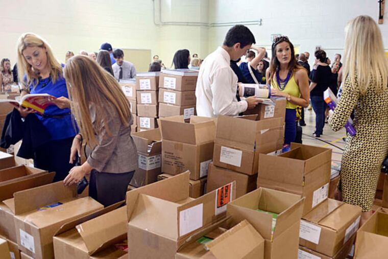 Teachers pore over textbooks at the Philadelphia Charter School for the Arts and Sciences at H.R. Edmunds. (Tom Gralish/Staff)