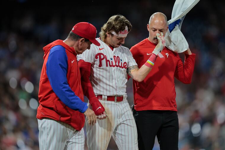 The Phillies' Bryson Stott gets checked out after being hit by Giants pitcher Camilo Doval during the ninth inning on Tuesday.