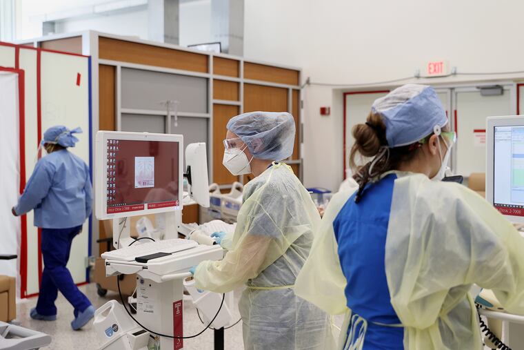 Medical workers input patient information on computers in the Boyer Pavilion lobby at Temple University Hospital, which was turned into a makeshift COVID-19 unit.