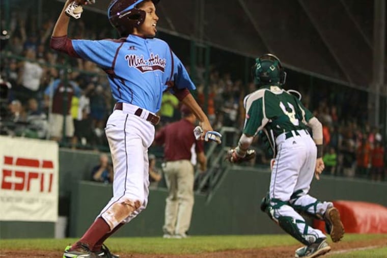 Taney's Scott Bandura exults after sliding home with a run during the Little League World Series in 2014.
