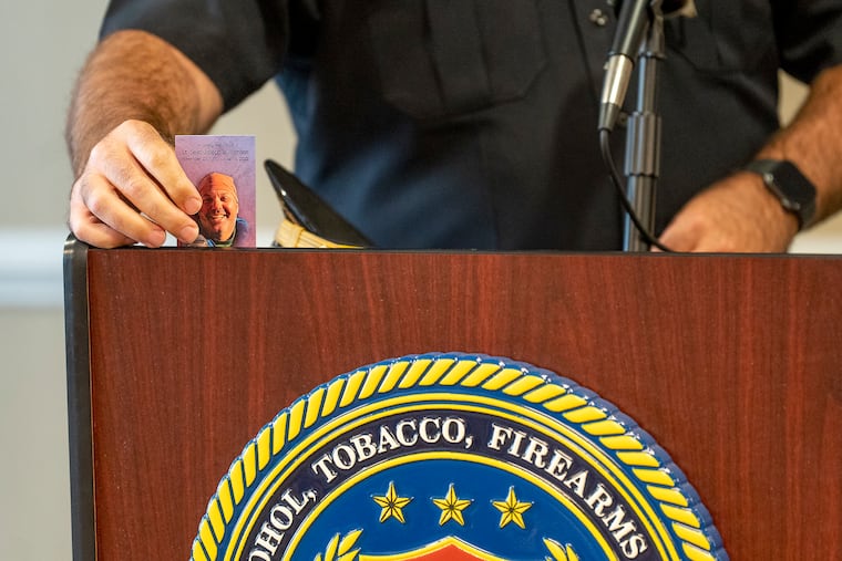 Fire Commissioner Adam Thiel places a photo of firefighter Lt. Sean Williamson on the podium during a press conference.