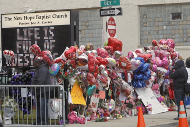 Fans created a makeshift memorial at the New Hope Baptist Church in Newark for Whitney Houston, a native of that city who died Saturday at 48. (Rich Schultz / Associated Press)