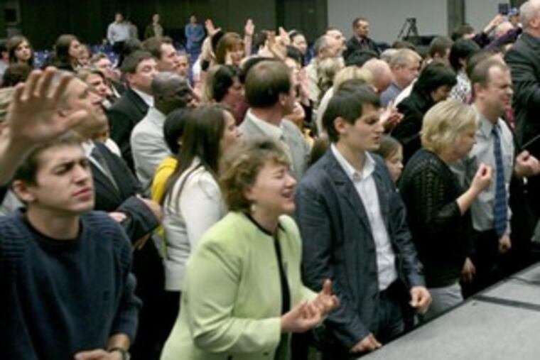 Adelaja, right, preaches to a rapt congregation in Sacramento. The pastor's megachurch claims 20 congregations in America, built mainly through Ukrainian- and Russian-speaking immigrants.