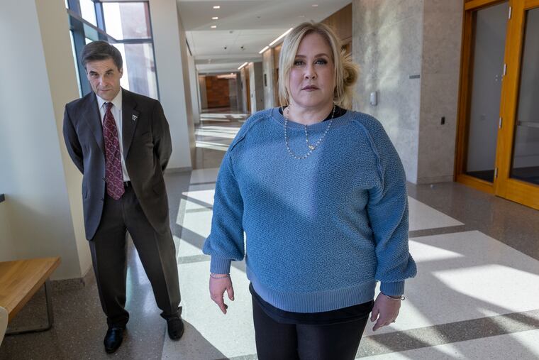 Raffaela Spone stands with her attorney Robert Birch outside of a courtroom in the Bucks County Courthouse in Doylestown. Spone, 51, is charged with harassment after prosecutors say she sent anonymous text messages to the parents of three teenage girls on her daughter's cheerleading team.