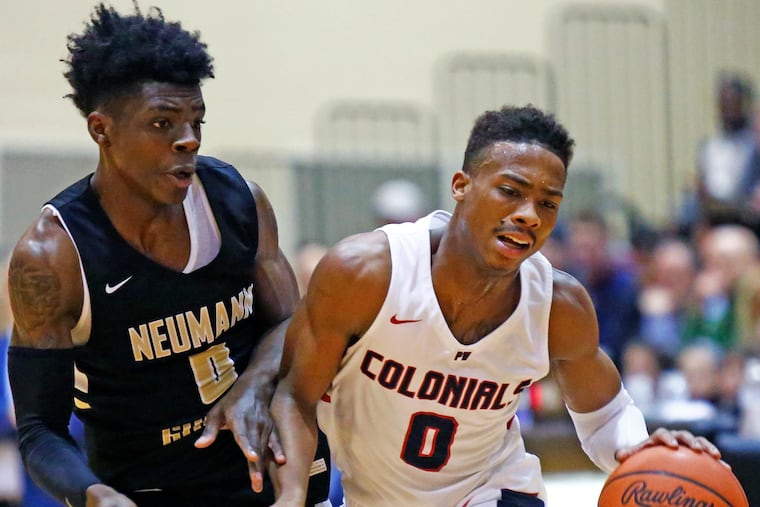 Ish Horn of Plymouth Whitemarsh (right) dribbles down court while defended closely by Chris Ings of Neumann-Goretti .