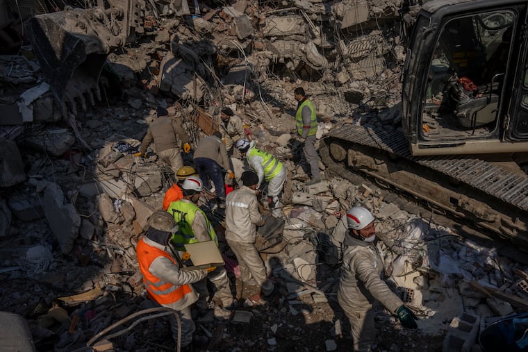 Members of a search and rescue team work on a collapsed structure after the earthquake in Antakya, southeastern Turkey, on Sunday.