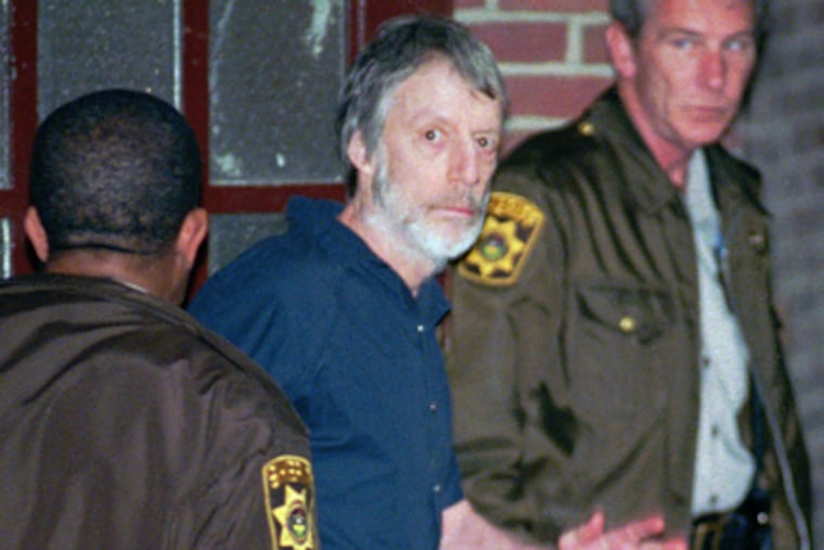 Millionaire murderer, John du Pont, waves as he is led into the holding area of the Delaware County Courthouse in Media, Pa., Thursday, May 30, 1996. du Pont died on Thursday at the age of 72. (AP Photo/Tim Shaffer)