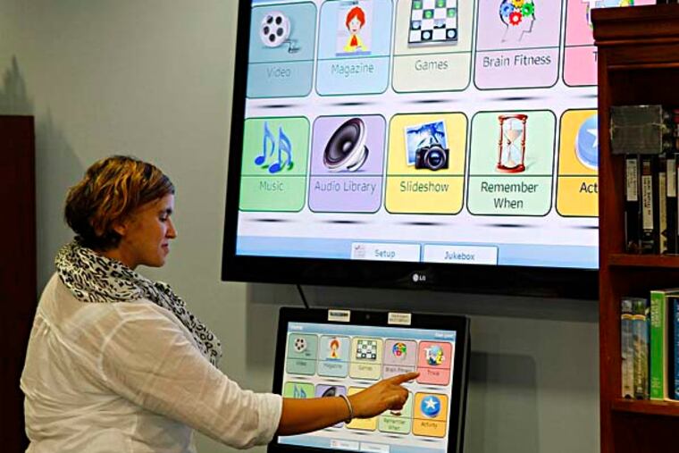 Elisabet Haile, recreation director at Barclay Friends in West Chester, selects a program from a computer with a LInkedSenior program. Catagories include magazine, brain training, trivia, music, and slideshows. September 9, 2014. ( MICHAEL S. WIRTZ / Staff Photographer )